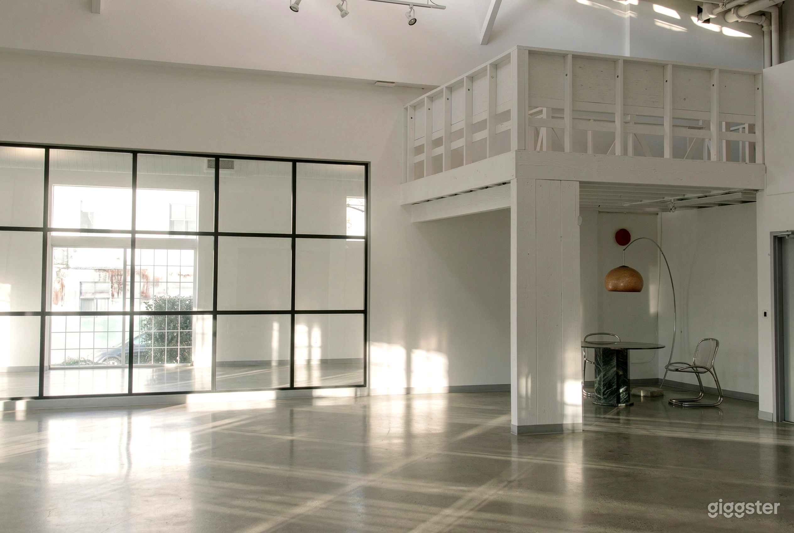 An empty modern style room with white walls, a glossy floor and a mirrored wall.