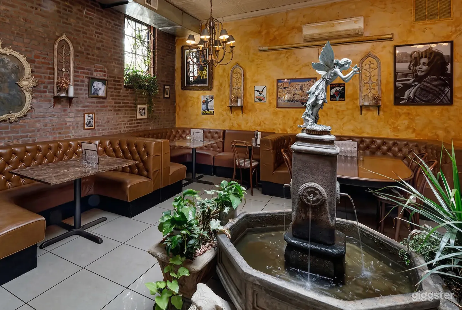 A large water fountain with a statue is central in a booth-filled restaurant.