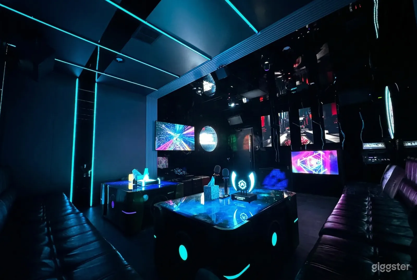 An event room with multiple screens is accented with blue lighting.