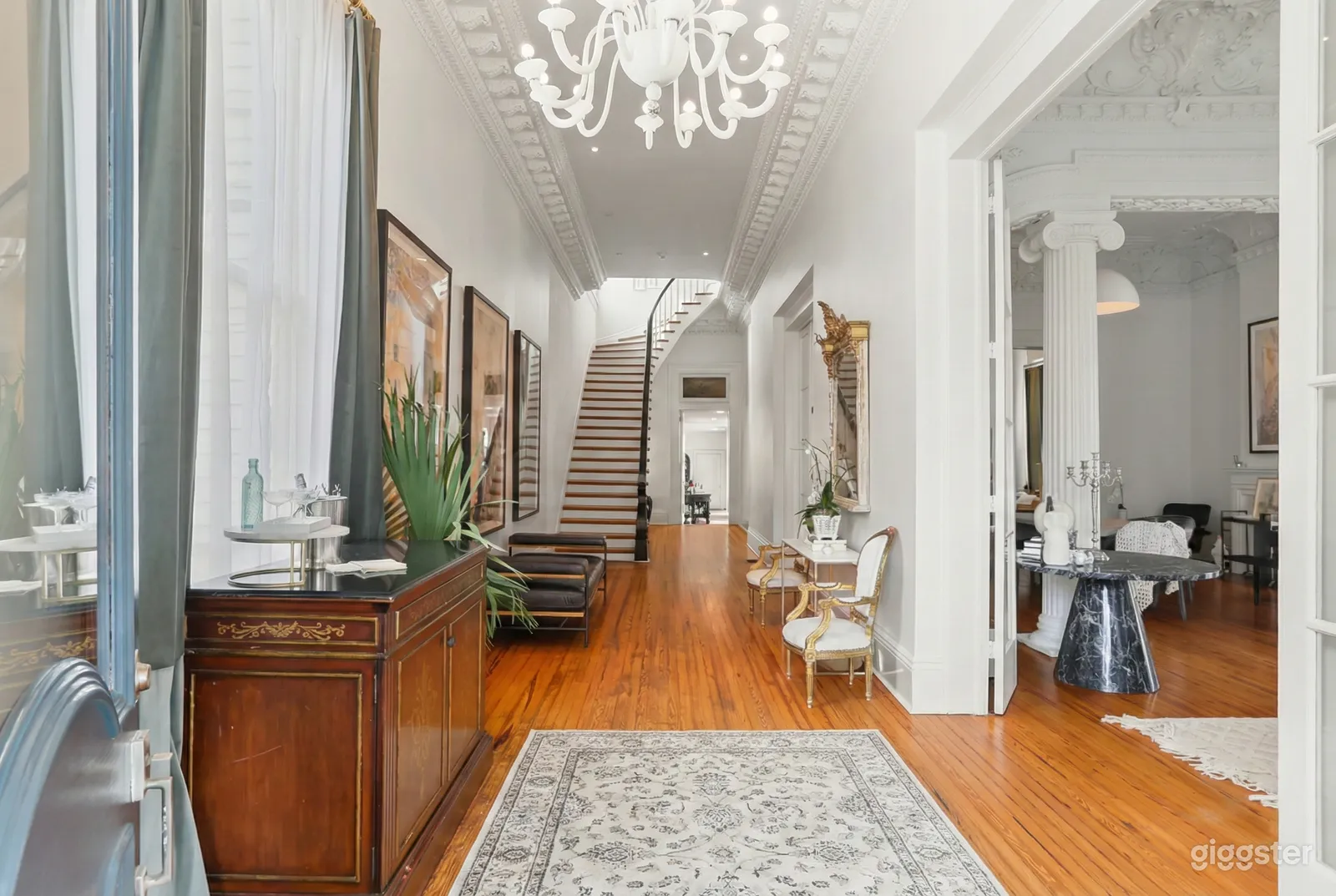 A curving stairway is the focal point of a white narrow room soon to host a prom.