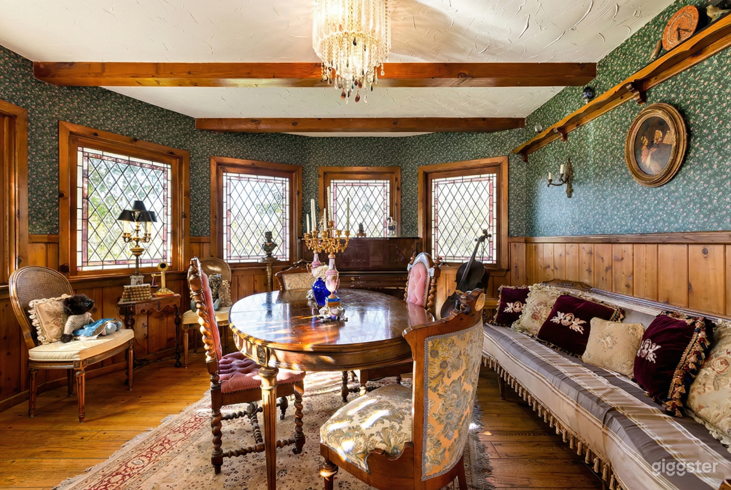 Angular room styled with Victorian furniture and a cushioned bench along the wall.
