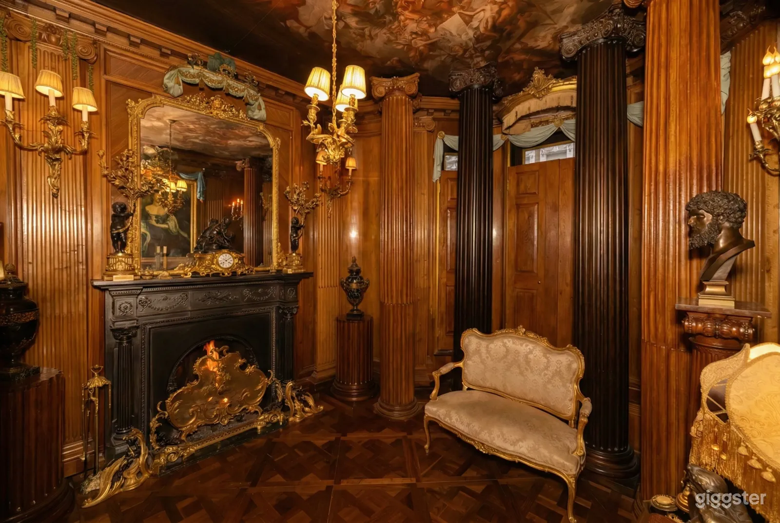 An ornate fireplace, a statue and vintage furniture decorate a traditional room.