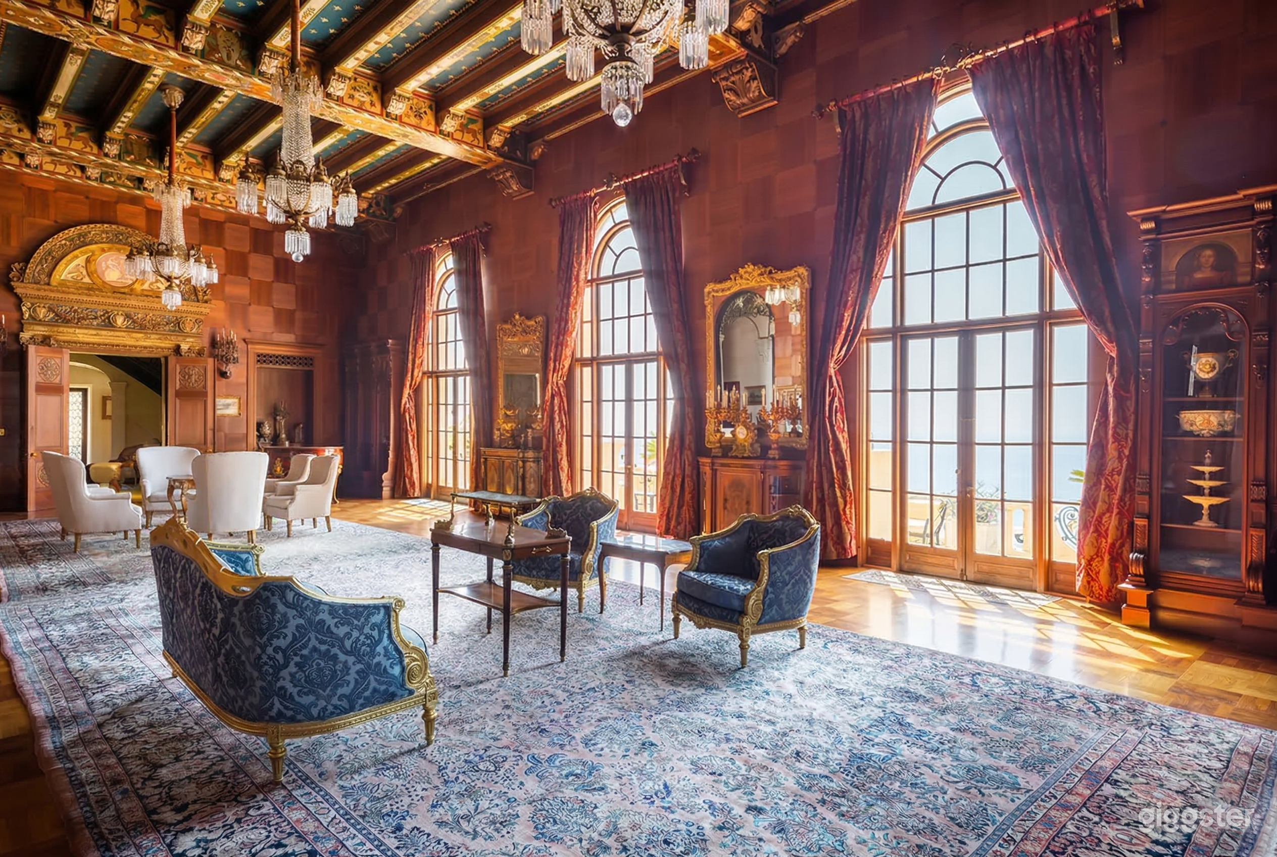 Victorian styled seating and decor in a room with large fully paned curtained windows.