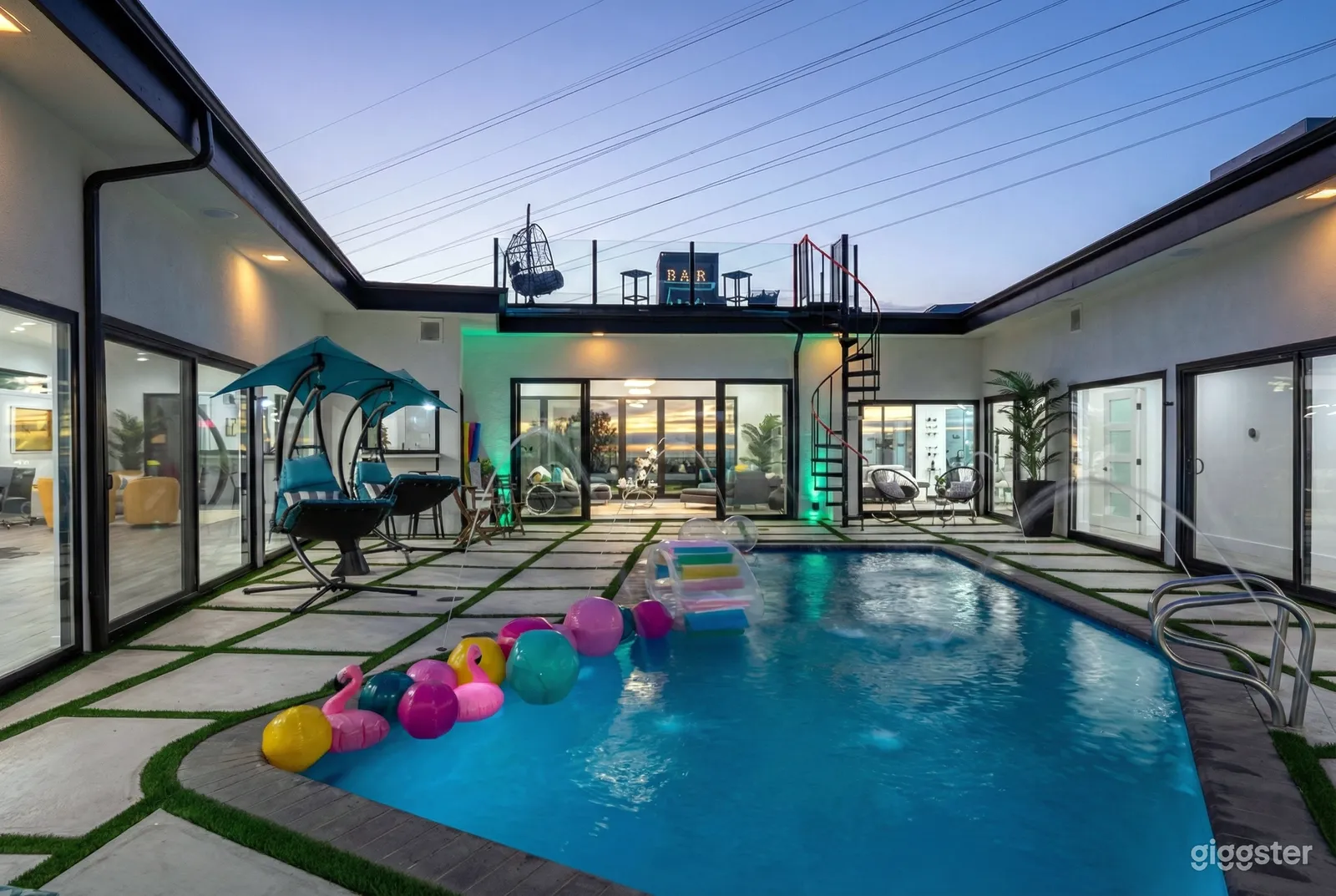 An inground pool is party-ready with balloons and pool toys.