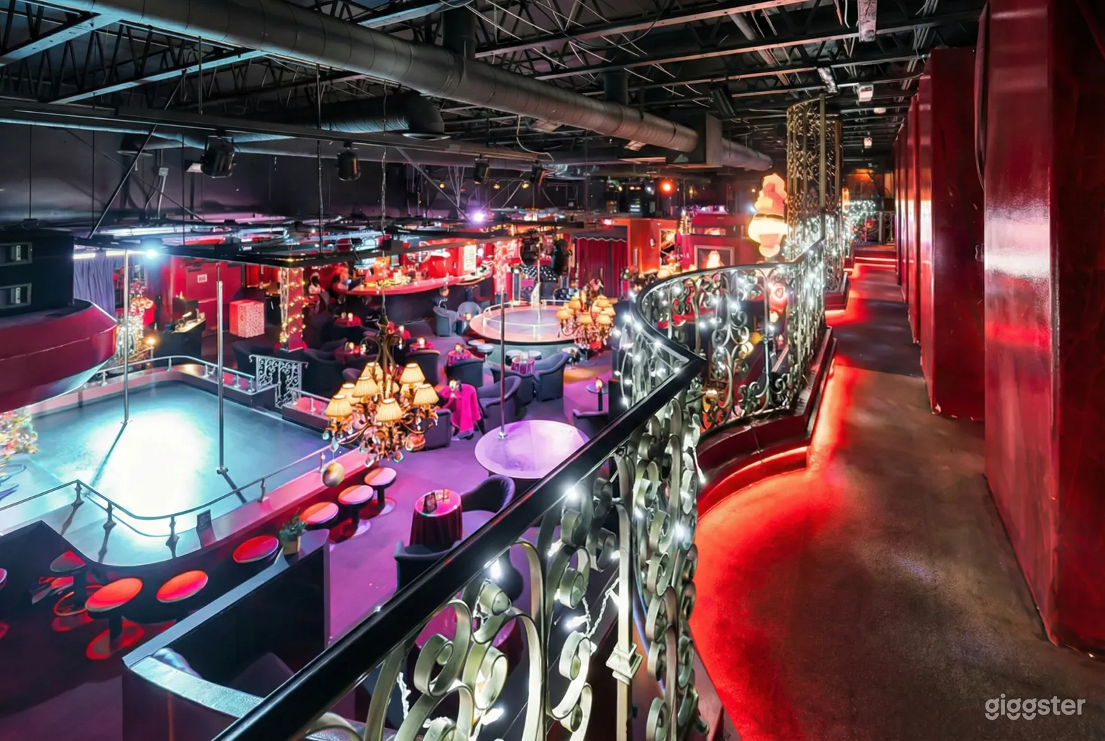 Bar venue with multiple seating and dancing zones lit in multicolored lights.