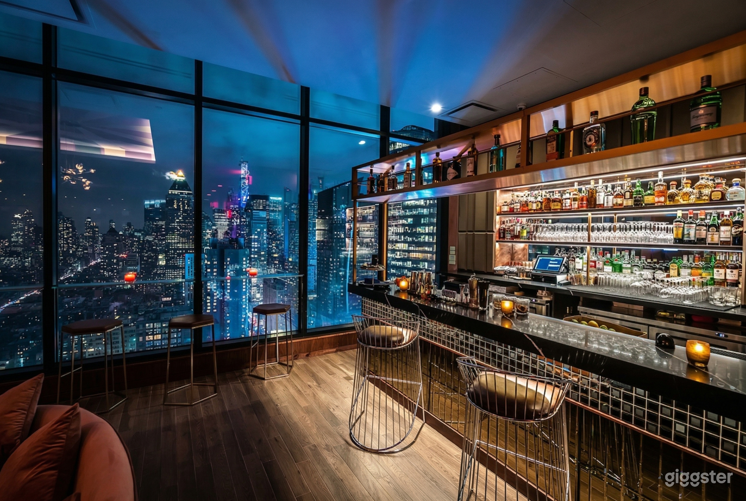 A rooftop lounge and bar with floor to ceiling windows and a panoramic view of the city.