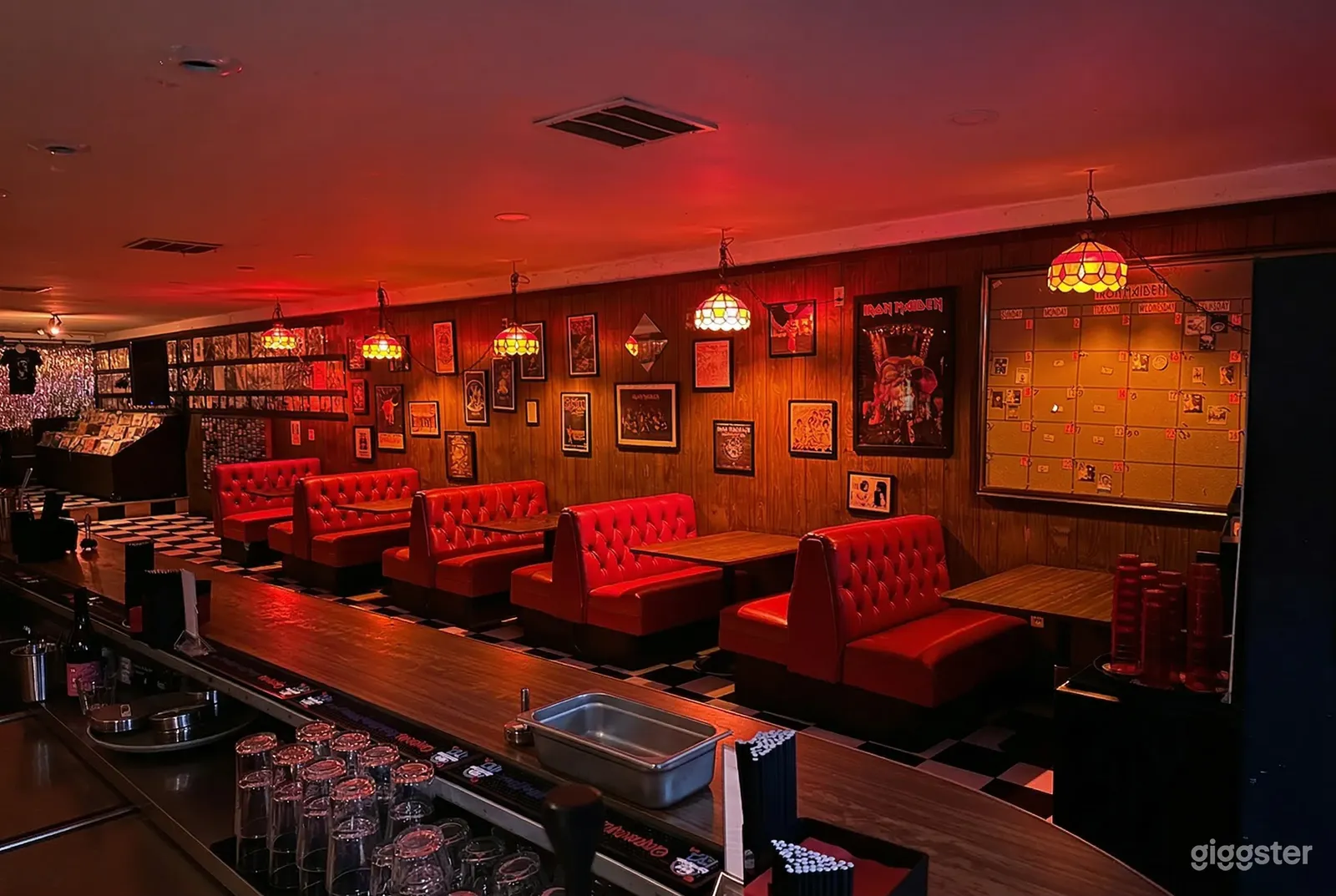 Red leather benches form the seating area of a traditional diner which is lit up in hues of red.