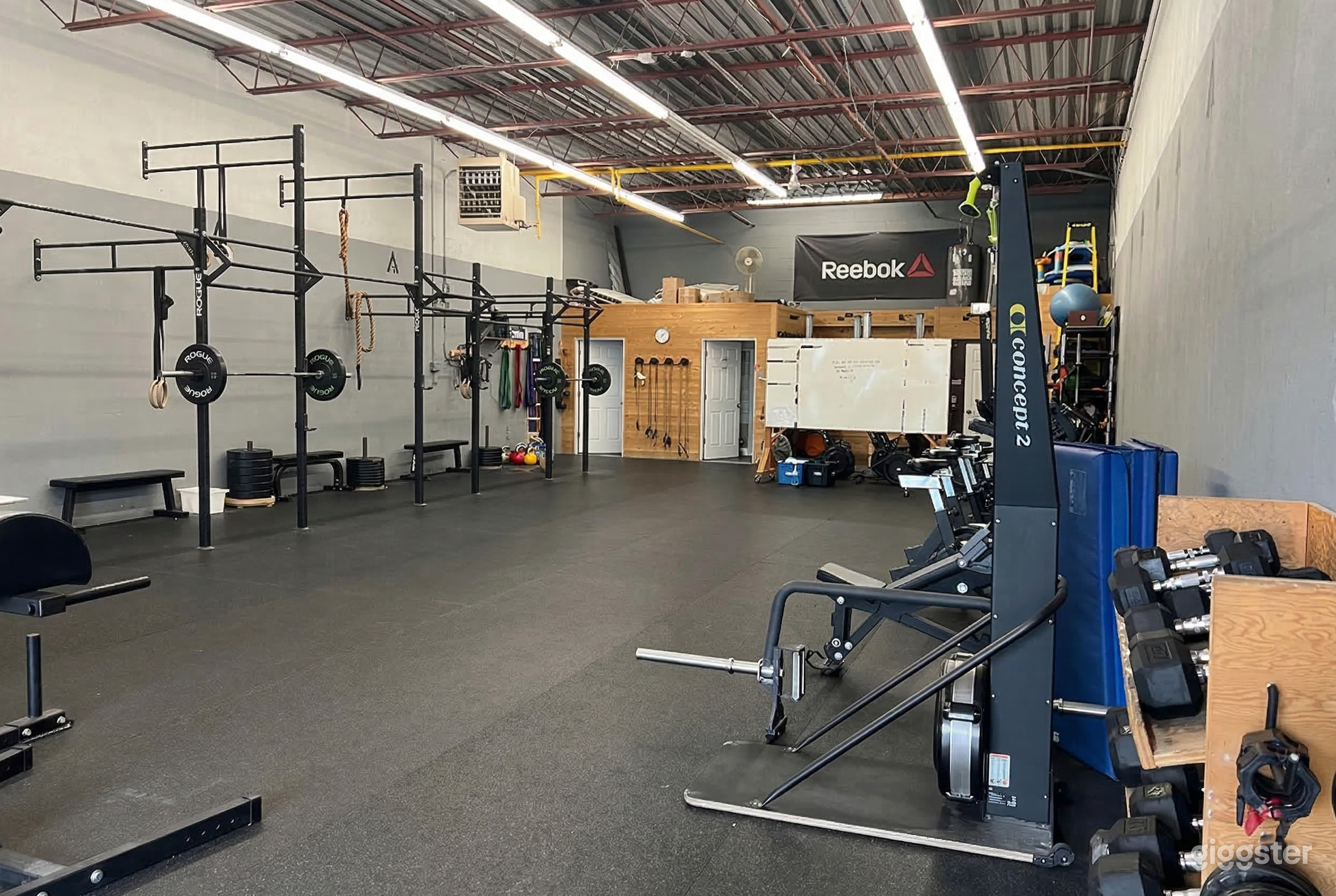 A gym space is open in the middle with weightlifting equipment on one side and exercise bikes on the other.