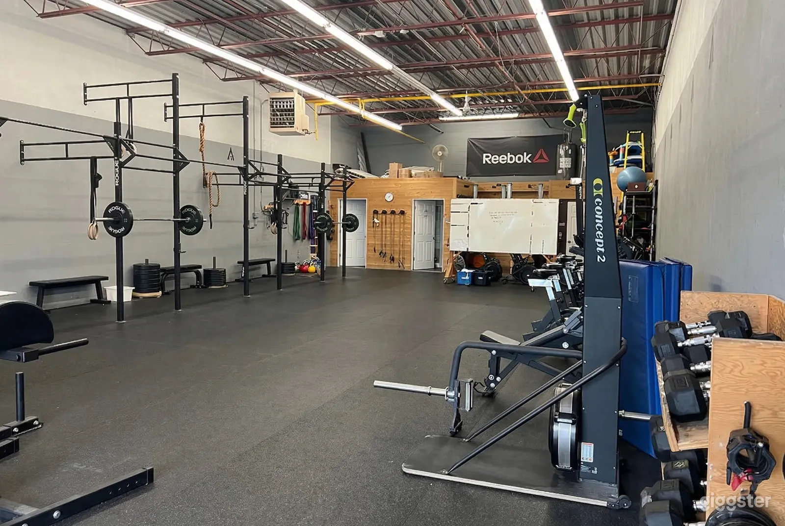 A gym space is open in the middle with weightlifting equipment on one side and exercise bikes on the other.
