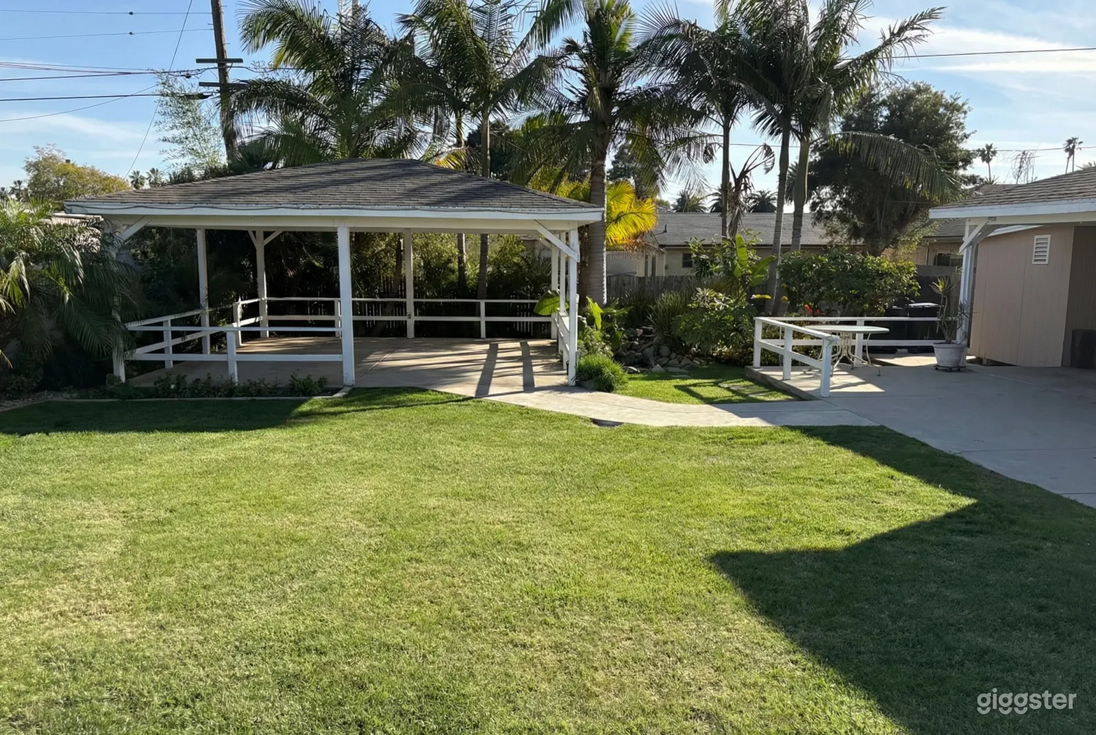 Large green backyard with plenty of grassy space and a big covered patio area.