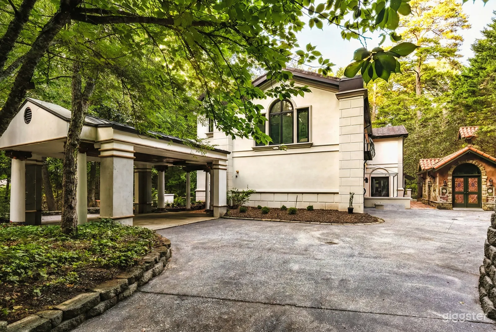 A white stucco home with garden spaces in front will host a garden party.
