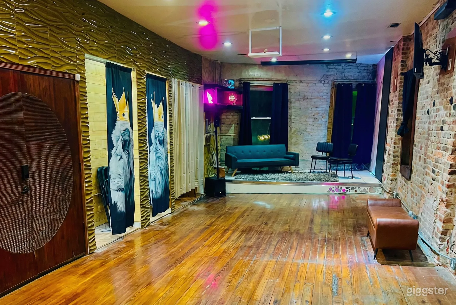 Turquoise couch is central to a room with a weathered wooden floor.