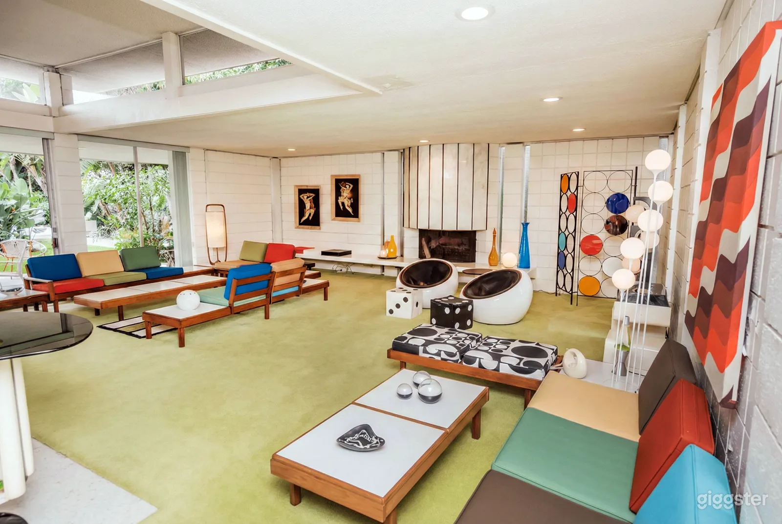 A large room with colorful cushioned benches facing long tables.