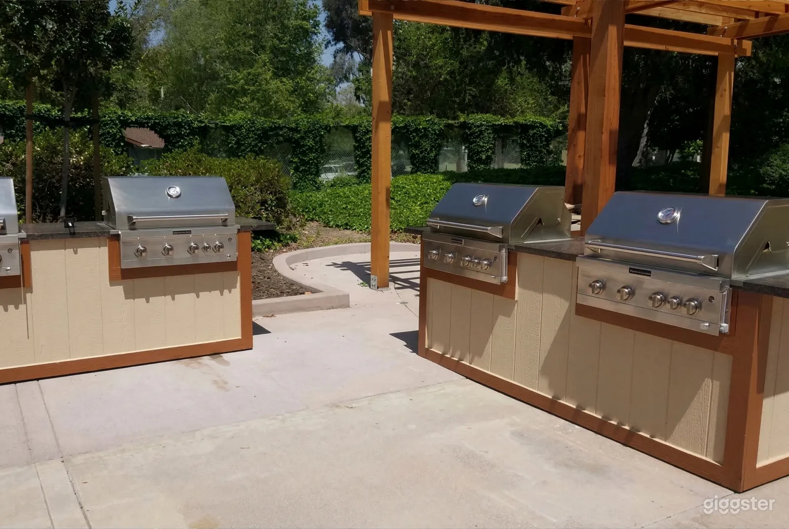 Four built-in barbecues are the focal point of a cement floored outdoor cooking area.