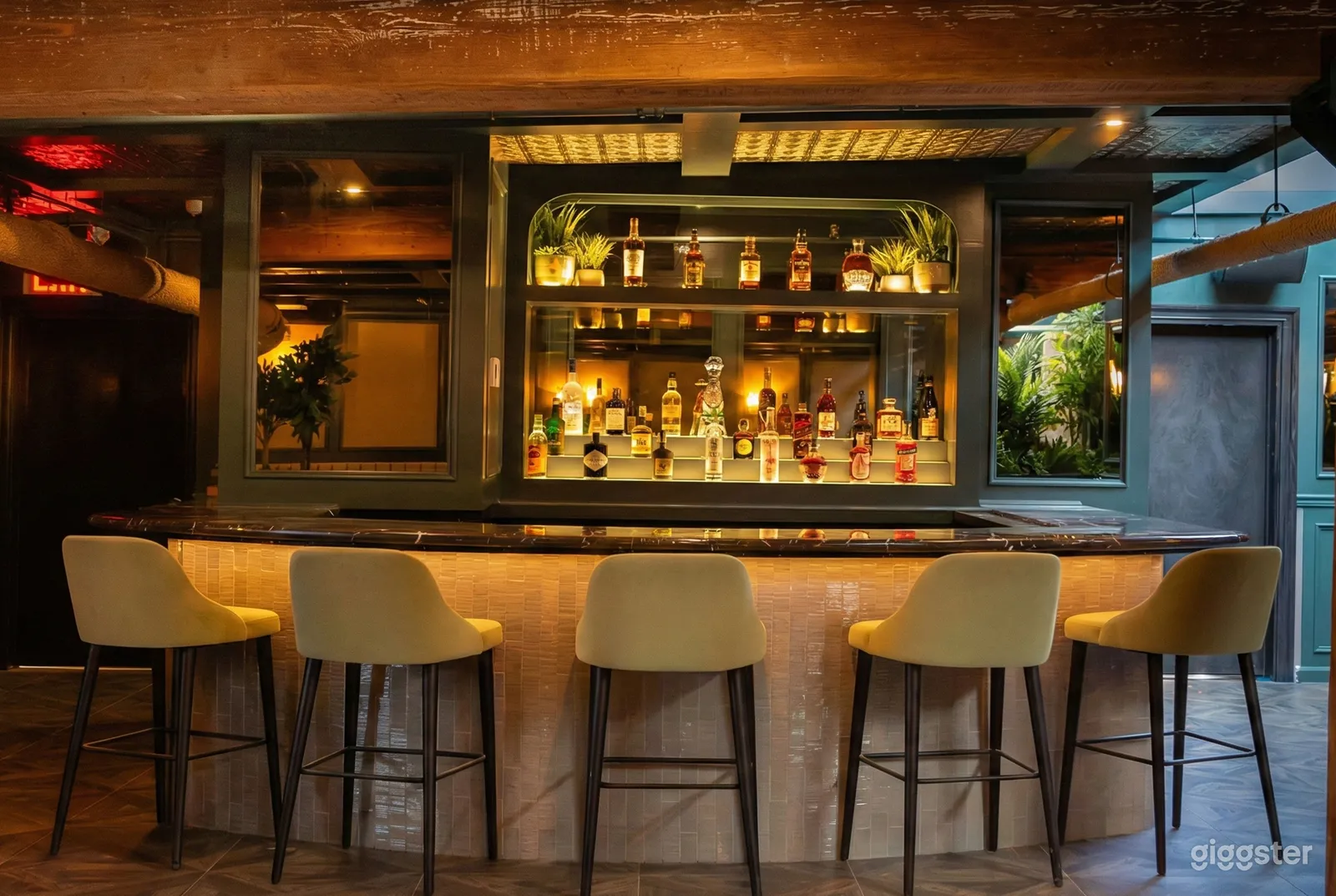 Five tall chairs facing a mirrored bar in a Mediterranean style room.