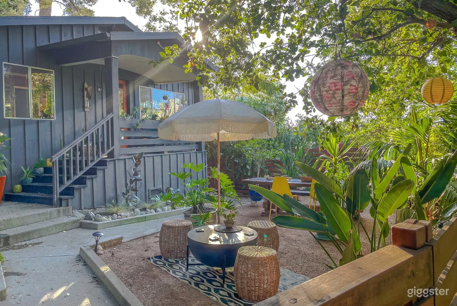 Tables of wicker and wood in a lush green tropical garden setting.