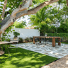 A bridal shower table on a stone patio under trees as prep for a bridal shower.
