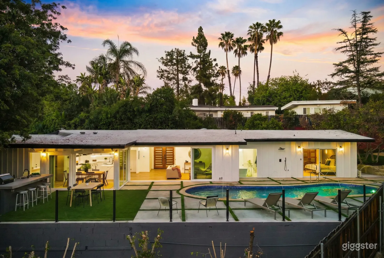 Well-lit modern venue with a long-style layout facing a pool deck with several lounge chairs.