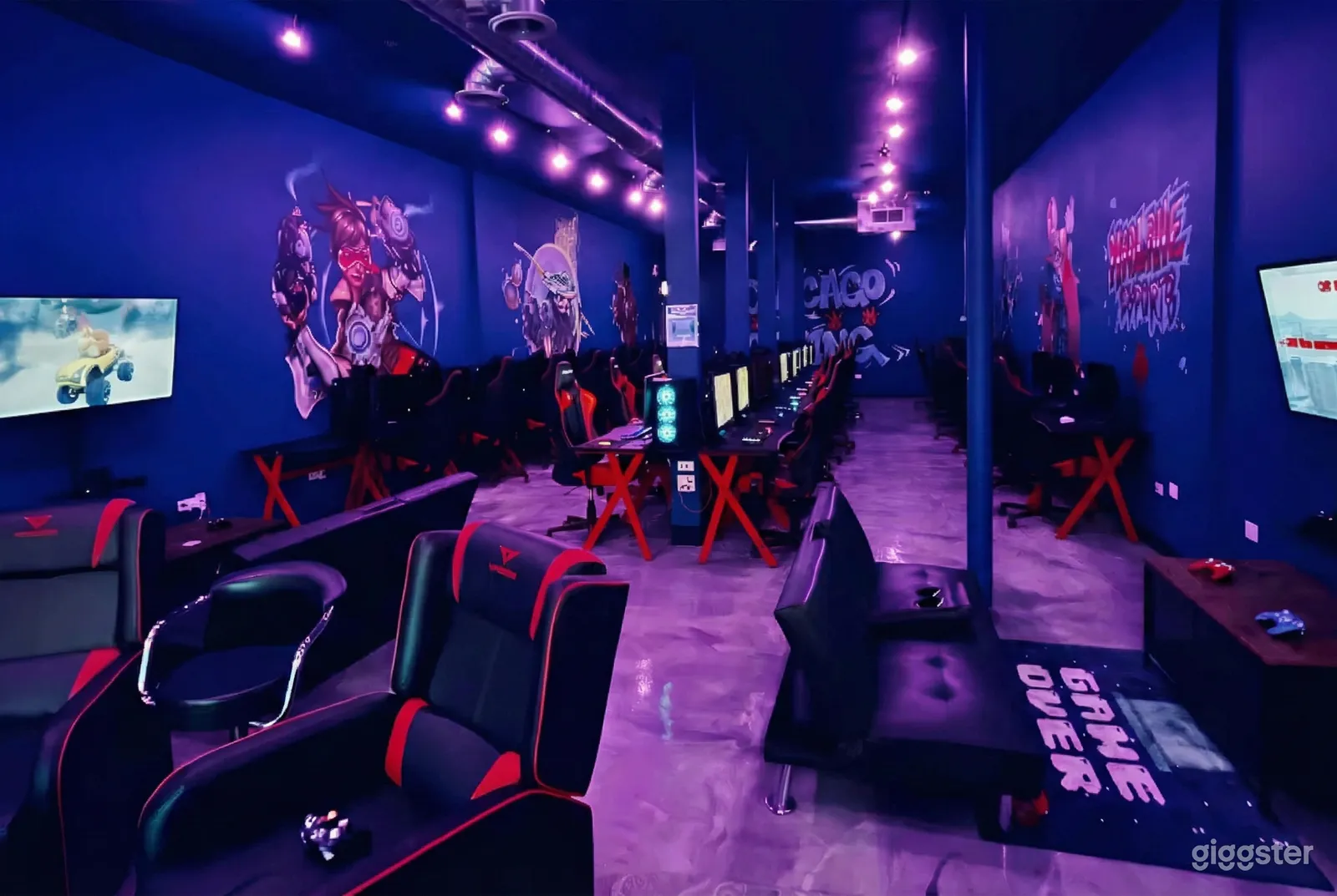 Games room with multiple stations and blue walls with purple flooring.