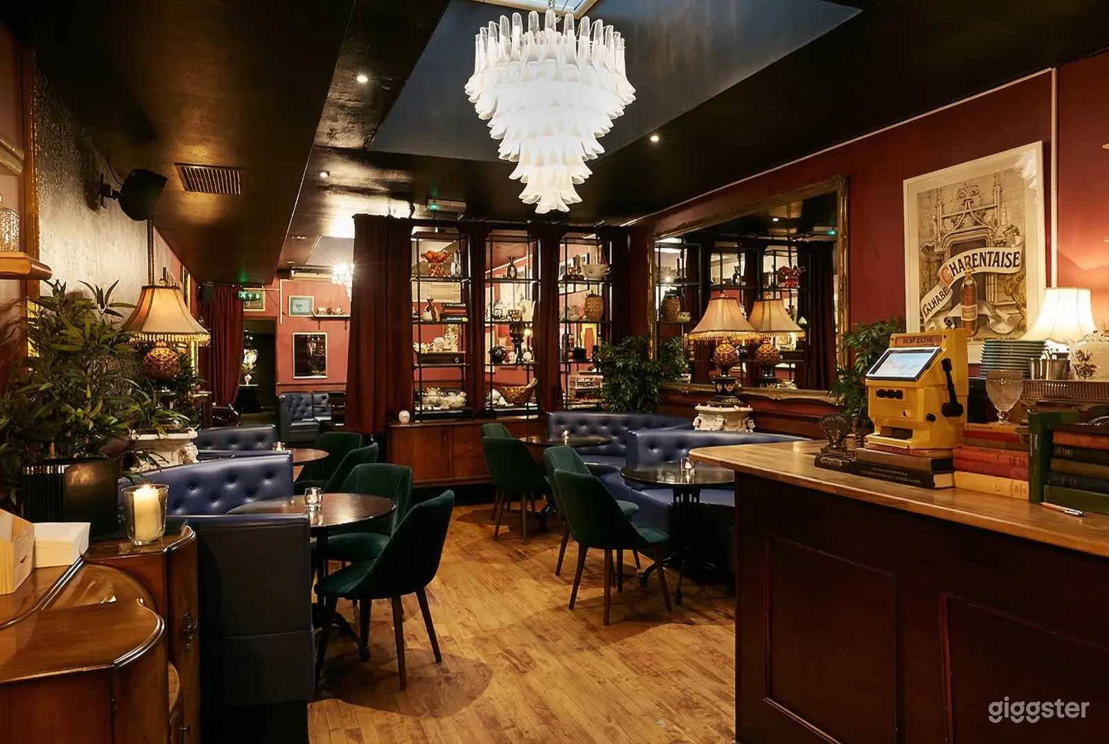 A traditionally styled restaurant with round tables, blue curved leather benches and chairs.