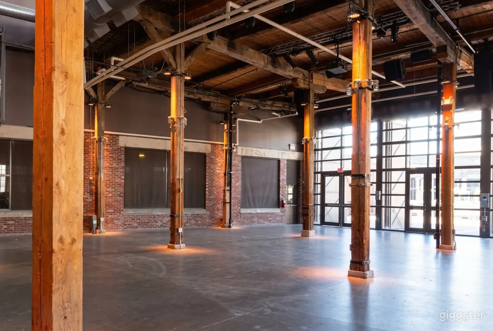 Sturdy wooden posts support a ceiling of beams in a warehouse space.